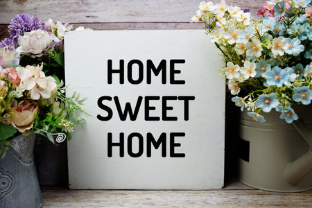 Home Sweet Home text with artificial tulip flower decorated on wooden backgroundの写真素材
