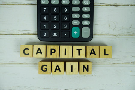 Capital Gain with wooden blocks alphabet letters and calculator on wooden backgroundの写真素材