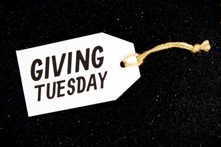Giving Tuesday text message on paper tag with space for copy background