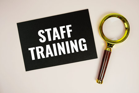 Staff Training text with magnifying glass top view on pink backgroundの写真素材