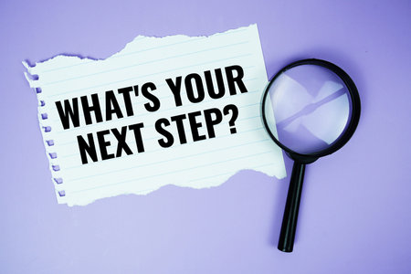 What's your next step? text written on paper torn top view on purple background