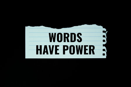 Words have power text written on paper torn top view on black backgroundの写真素材