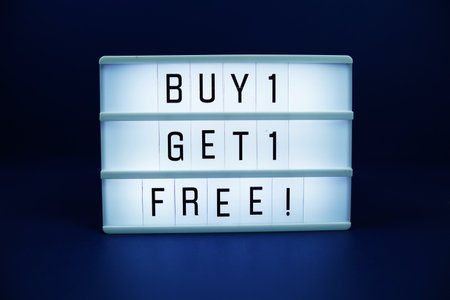 Buy 1 Get 1 Free! letterboard text on LED Lightbox on blue backgroundの写真素材