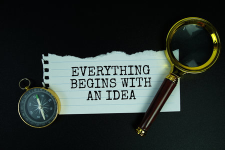 Everything Begins with an Idea text motivational and inspiration quote with compass and magnifying glass on black backgroundの写真素材
