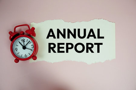 Annual Report text written on paper card with alarm clcok on pink backgroundの写真素材