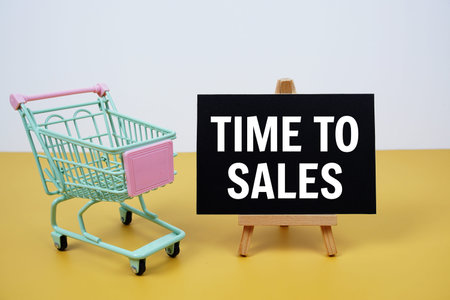 Time To Sales text message and trolley shopping cart on yellow backgroundの写真素材