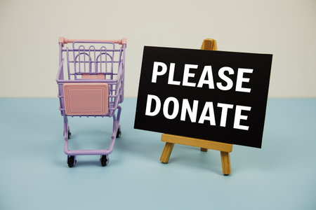 Please Donate text message and trolley shopping cart on blue backgroundの写真素材