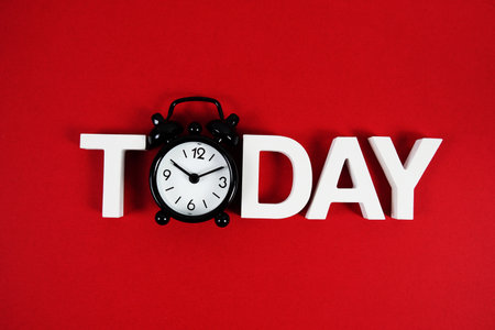 Today alphabet letters with alarm clock on red backgroundの写真素材