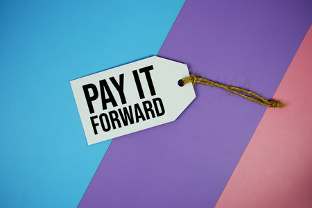 Pay It Forward text on price tag top view on purple geometric backgroundの写真素材