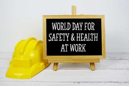 World Day For Safety &amp; Health at Work Sefety Day text on blackboard with safety helmet on wooden backgroundの写真素材