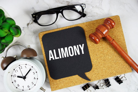 Alimony text with alarm clock and gavel on marble backgroundの写真素材