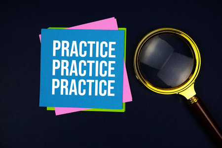 Practice text with sticky note and magnifying glass on black backgroundの写真素材