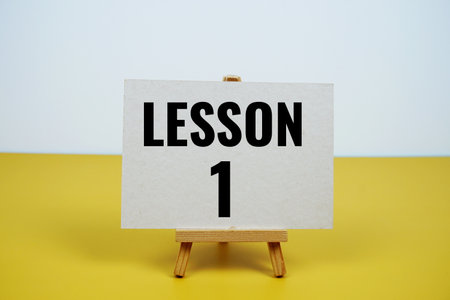 Lesson one text written on paper card with easel standing on purple backgroundの写真素材