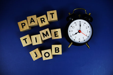 Part Time Job with wooden blocks alphabet letters and alarm clock on blue backgroundの写真素材