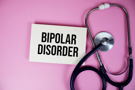 Bipolar Disorder text with stethoscope top view on pink background, Healthy and wellness concept