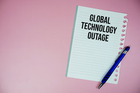 Global Technology Outage text written on paper with pen on pink backgroundの写真素材