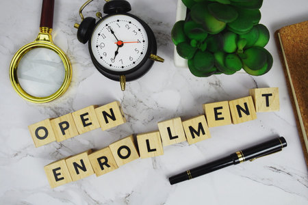 Open Enrollment with wooden blocks alphabet letters and Magnifying glass on marble backgroundの写真素材