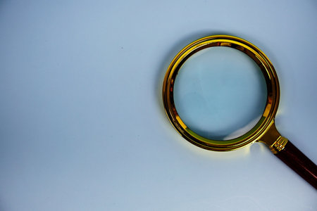 Magnifying glass with space for copy top view on blue backgroundの写真素材