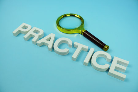 Practice alphabet letters and magnifying glass top view on blue backgroundの写真素材