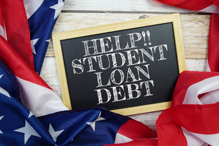 Student Loan Debt text messege with USA flag on wooden backgroundの写真素材