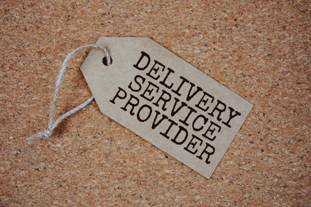 Delivery Service Provider text on price tag top view on cork paper backgroundの写真素材