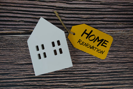 Home Renovation text on price tag with white house model flat lay on wooden backgroundの写真素材