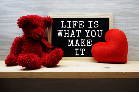 Life Is What You Make It Motivational and Inspiration Quotes on chalkboard with teddy bear on wooden backgroundの写真素材