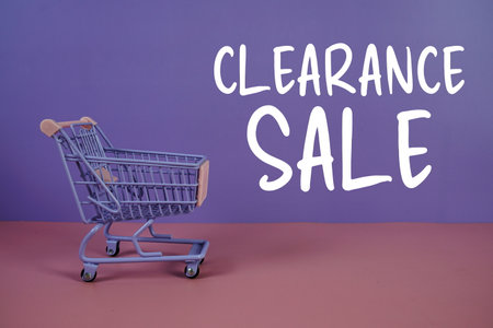 Clearance Sale text with trolley shopping cart on purple and pink geometric backgroundの写真素材