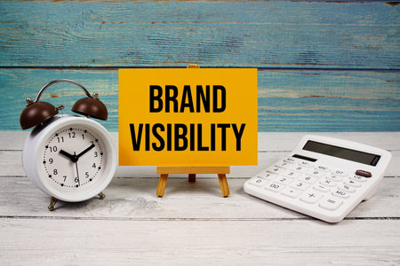 Brand Visibility text written on paper card with calculator and alarm clock on wooden backgroundの写真素材