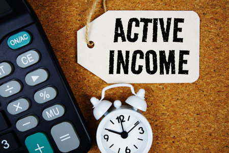 Active Income text on price tag with calculator on cork board background