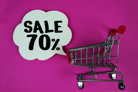 Sale 70% text with speech bubble and trolley shopping cart on pink backgroundの写真素材