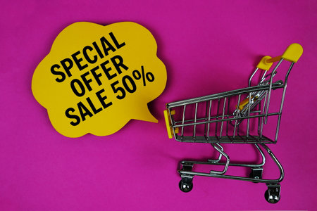 Special Offer Sale 50% text with speech bubble and trolley shopping cart on pink backgroundの写真素材