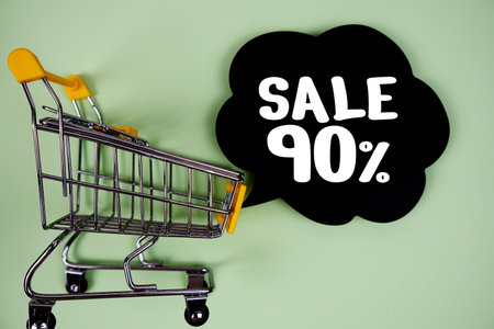 Sale 90% text with speech bubble and trolley shopping cart on green backgroundの写真素材