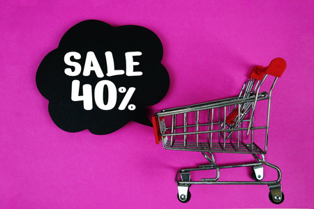 Sale 40% text with speech bubble and trolley shopping cart on pink backgroundの写真素材