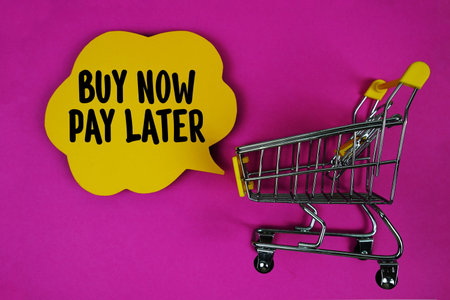 Buy Now Pay Later text with speech bubble and trolley shopping cart on pink backgroundの写真素材