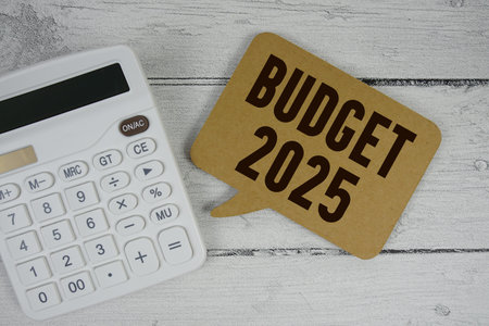 Budget 2025 text with calculator on wooden background
