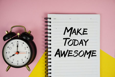 Make Today Awesome text written on notepad with alarm clock on pink backgroundの写真素材