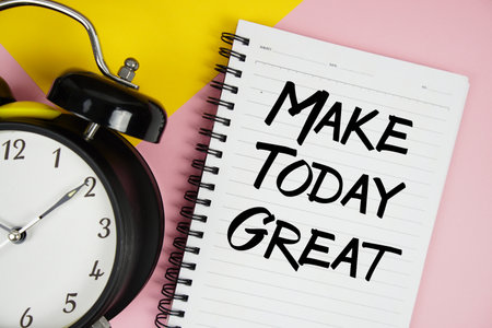 Make Today Great text written on notepad with alarm clock on pink backgroundの写真素材