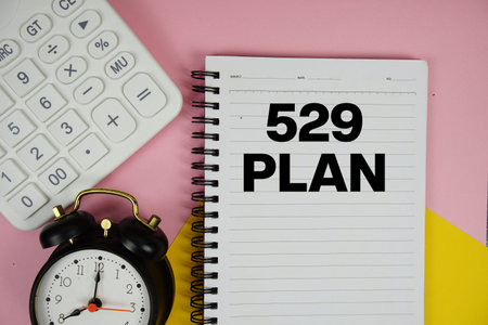 529 Plan text written on notepad with calculator and alarm clock on pink background