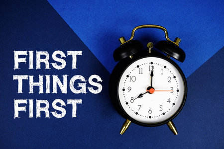 First Things First text with alarm clock on blue backgroundの写真素材