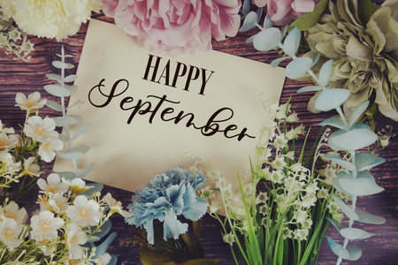 Happy September text with flowers bouquet decoration on wooden backgroundの写真素材