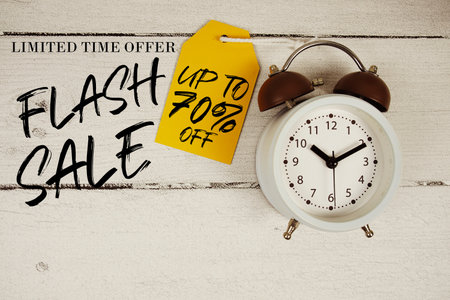 Flash Sale up to 70% off text with alarm clock on wooden backgroundの写真素材