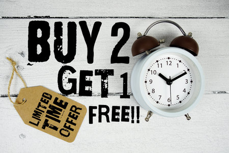 Buy 2 Get 1 Free Limited Time Offer text with alarm clock on wooden backgroundの写真素材
