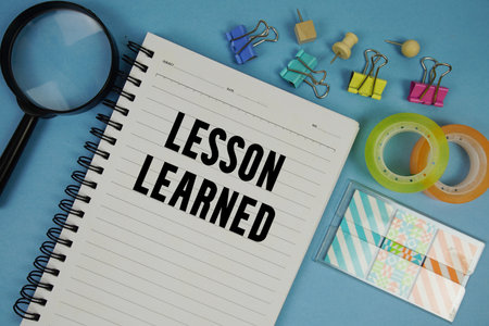 Lesson Learned text with magnifying glass on blue backgroundの写真素材