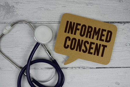 Informed Consent text with Stethoscope on wooden backgroundの写真素材