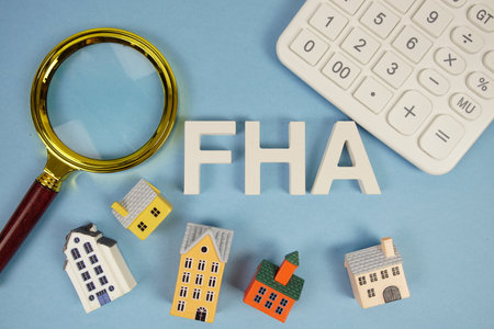 FHA abbreviation of Federal Housing Administration alphabet letters with house model, magnifying glass and calculator on blue backgroundの写真素材