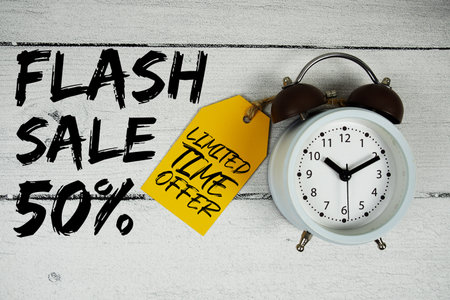 Flash Sale 50% text with alarm clock on wooden backgroundの写真素材