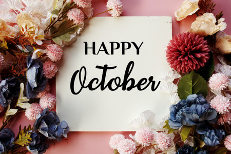 Happy October text with flowers decorations on pink backgroundの写真素材
