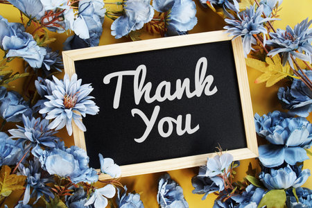 Thank You text with flowers decoration on yellow backgroundの写真素材