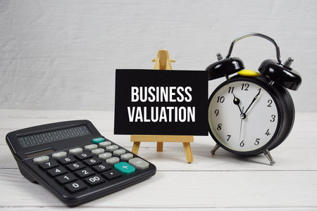 Business Valuation text with alarm clock on wooden backgroundの写真素材